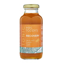 Mrs. Toddy’s Recovery Tonic bottle with turmeric, ginger, and lemon on linen background