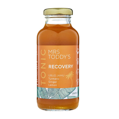 Mrs. Toddy’s Recovery Tonic bottle with turmeric, ginger, and lemon on linen background